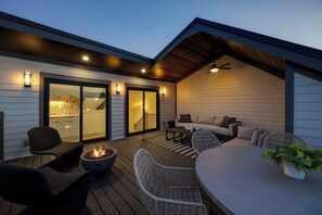 4th Floor: Private partially covered rooftop deck offering stunning city-skyline views and diverse outdoor furnishings for lounging and dining including a fire pit.