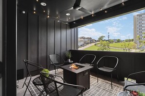 Top floor private patio with a gas firepit, string lights, and plenty of seating for your group to convene and enjoy some fresh air. Please note we do not supply the propane for the firepit.