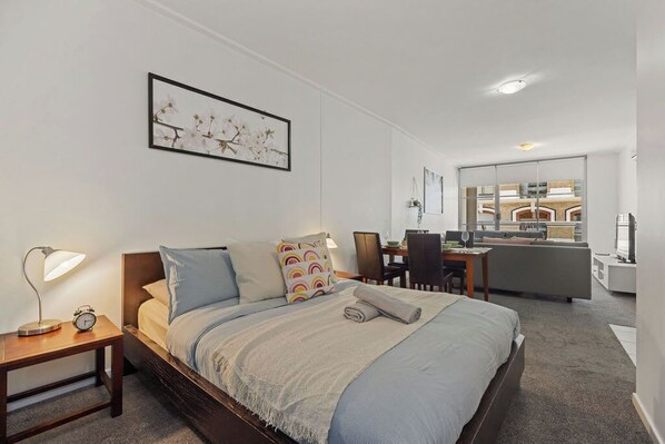 A bedroom area with a queen sized bed & plush pillows.