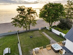 Panoramic aerial shot of the backyard revealing beachfront access and various outdoor facilities.