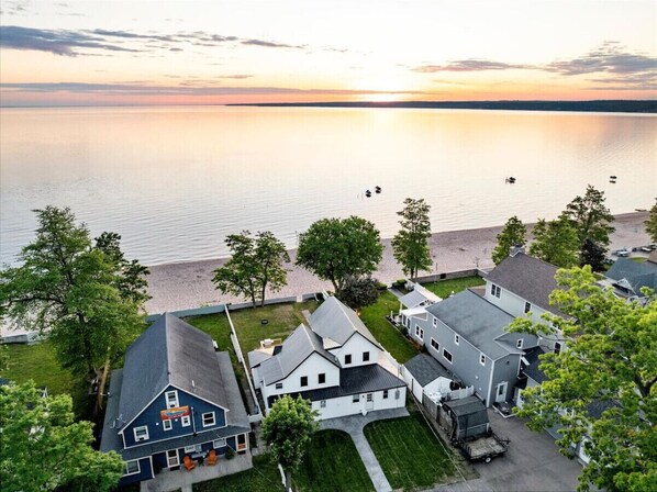 Aerial shot capturing the coastal charm of Sylvan Beach, highlighting a beachfront residence amidst natural beauty and serene waters.