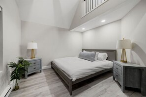 Spacious bedroom featuring a luxurious king-size bed and an adjoining loft with a comfortable full-size bed, offering versatile sleeping arrangements.