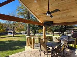Large covered dining space and additional seating for a family gathering. Enjoy a delicious meal with the outdoor BBQ grill.