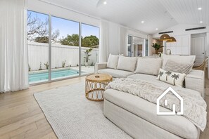 Open plan living, dining and kitchen which overlooks the pool