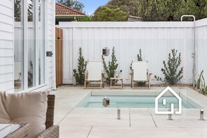 A plunge pool heated for year-round indulgence with an outdoor hot water shower