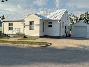 View of front entrance from the street and east entrance from the driveway.