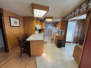 Standing in the living room showing seating for three at the bar.