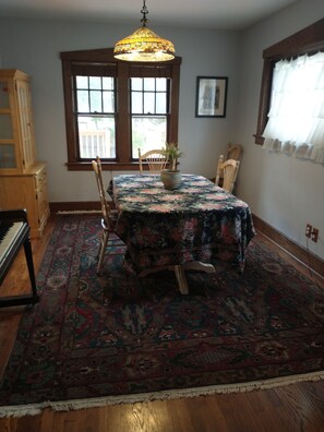 Dining room with piano and cabinet.