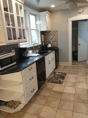 Newly painted kitchen with granite counter and modern appliances.