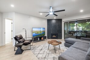 Living room with smart TV, board games, fireplace