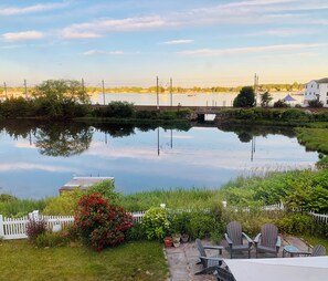 View of back of the house, fully fenced back yard, steps leading down to dock