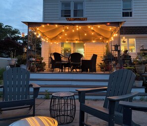 Fire pit on blue stone patio, dining on deck