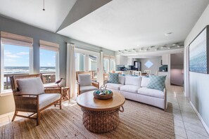 Large windows offering panoramic views illuminate this spacious and cozy living room