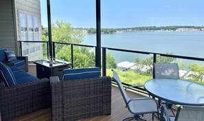 Expansive covered deck w/ panoramic views, plush seating, fire table, & dining 