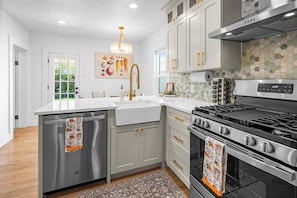 Kitchen with all new stainless appliances, quartz countertops, farmhouse sink.