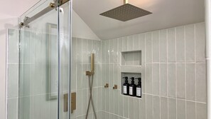 Enjoy luxurious rejuvenation in the modern luxe bathroom with a rain shower. 