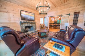 Living area with game room and stone wood-burning fireplace