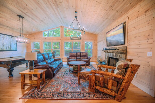 Living area with game room and stone wood-burning fireplace 