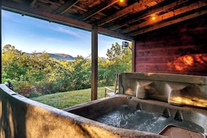 Immerse yourself in nature while soaking in our hot tub - the perfect way to relax and take in the stunning scenery surrounding your cabin retreat.