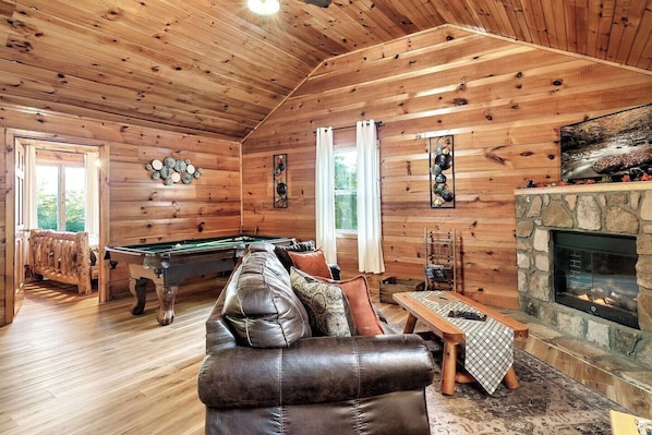 "Escape to rustic paradise: Cozy up by the fireplace, play pool, and relax in style with a 42 inch TV, all while having a glimpse of the stunning driftwood style bed and a charming wooden tile floor."