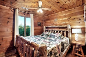 "Sleep in style and comfort: Our stunning queen size bed boasts a unique driftwood design, complemented perfectly by a beautiful glass window and cozy corner lamp. Stay cool with our convenient ceiling fan and enjoy the perfect temperature."