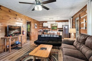 "Simple yet stylish cabin living at its finest. Cozy couch, TV, white ceiling, and fully equipped kitchen for comfort and convenience. "
#cabinlife 
#cozyliving 
#kitchengoals"