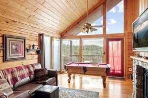 "Billiards with a view - enjoy your game while surrounded by stunning panoramic scenery in this sleek glass-walled cabin."