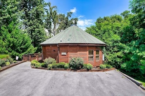 Immerse yourself in the beauty of the outdoors with this enchanting wooden structure embraced by a picturesque landscape of trees and bushes