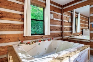 Immerse yourself in luxury with a spacious jacuzzi tub by the window, the perfect spot to relax and unwind.