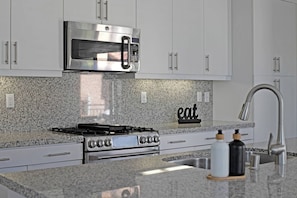 Beautiful granite countertops with white cabinetry and stainless steel appliances
