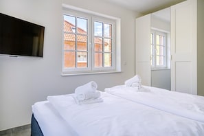 Schlafzimmer mit ausreichend Stauraum und TV