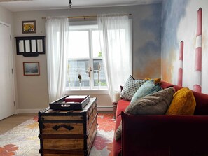 A living room inspired by the heart of Nova Scotia, featuring iconic Smokestacks wall art and a cozy sofa designed for ultimate comfort.