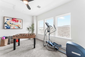 Loft area with foosball table, games, elliptical, and yoga mats