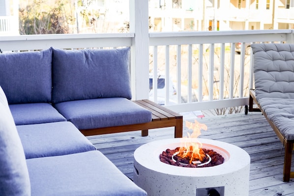 Private outdoor space with a sectional couch, propane fire pit, ring toss, & chaise lounge chair