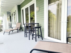 Spacious private balcony with 2 lounge chairs and a bar table with 2 stools