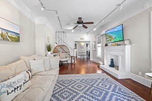 The living room is versatile, perfect for both entertaining and unwinding. Its wood floors and intricate trim seamlessly blend historic charm with modern luxury.