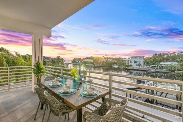 Expansive Wrap-Around Corner Balcony with Dining and Lounge Areas at Twilight