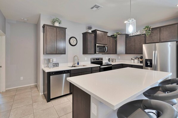 Kitchen with fridge, flattop stove, dishwasher, Keurig coffee maker