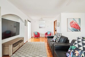 Relax in the main living area, offering multiple leather lounges and a central TV for easy viewing. Ceiling fans and cooling ensure your comfort.