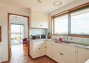 Whip up a quick bite in the sunlit kitchen, equipped with essentials like an oven and toaster. 