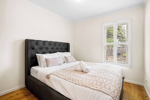 The light and airy first bedroom includes a queen-size bed and a built-in closet.
