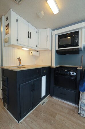Kitchen. Stove with 3 burners and over, microwave. We do have a coffee maker.