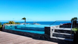 Enjoy the stunning shared terrace with an infinity pool featuring a transparent glass edge, offering breathtaking ocean views. #modernpool #oceanview
