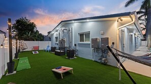 Shared backyard with a hammock, egg chair, and games like cornhole, spike ball, battle putt, and giant Connect 4. Perfect for family and friends.