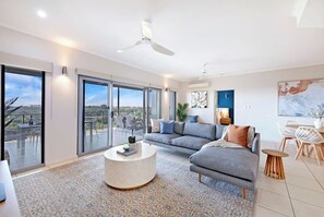 The open-plan living area includes a comfy sofa and chaise to settle in with some TV, with sliding glass doors opening to the sprawling private balcony. 