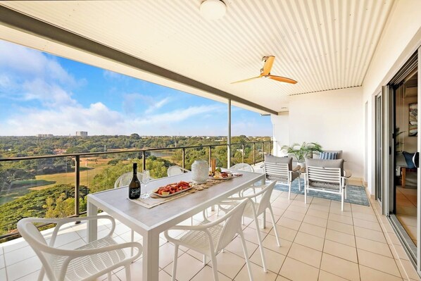 A sprawling balcony is complete with a six-seater table and comfortable seating, offering plenty of space to relax and entertain. 
