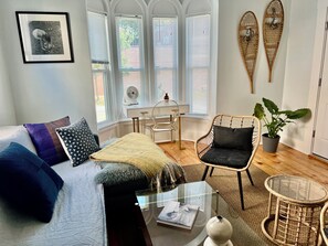 Living room with flat screen TV and desk overlooking North Street. 