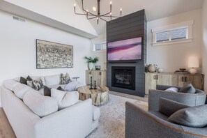 Comfy living area with natural light, fire place and tv
