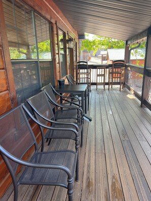 Covered front porch with seating, table and chairs.