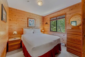 Bedroom 1: Queen bed, closet, dresser, forested views, main floor